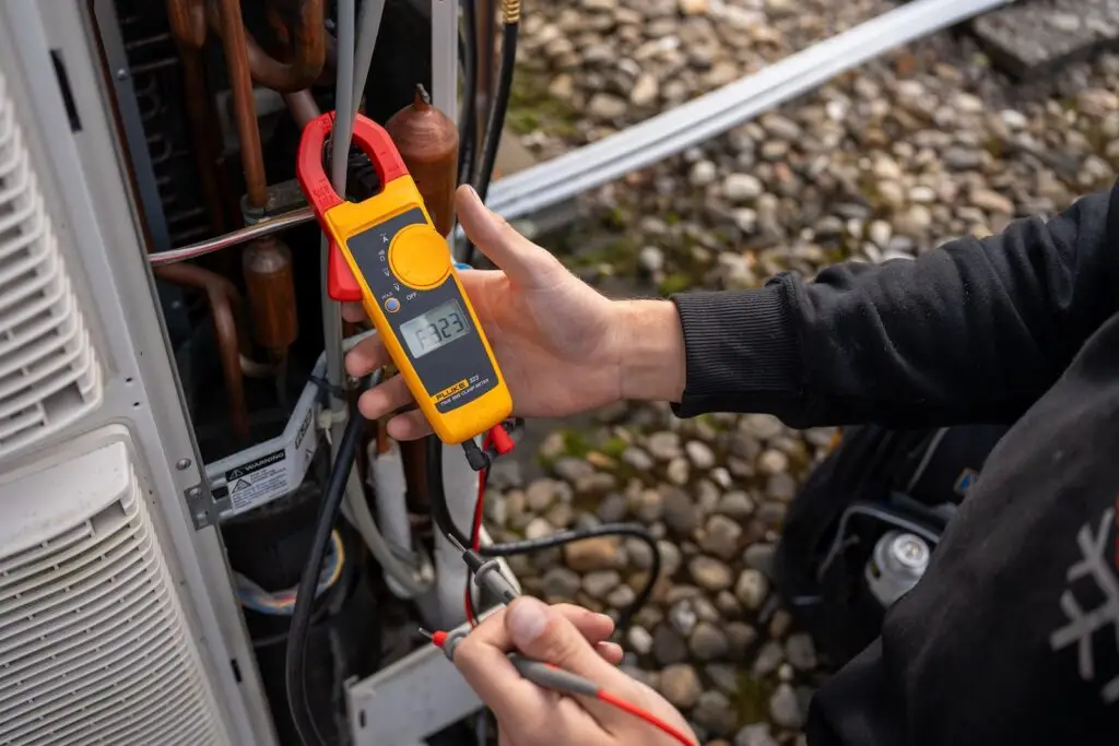 Elektrische meting met een stroomtang tijdens airco onderhoud door Jadikoel