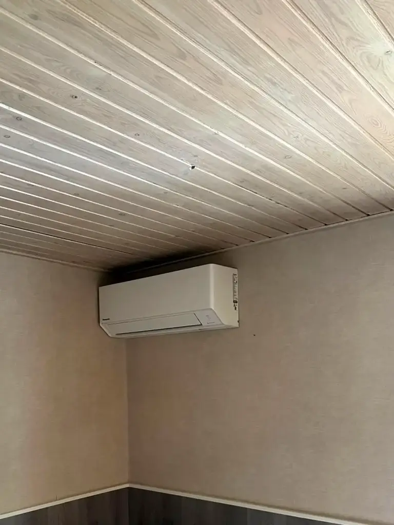 Panasonic airco binnenunit in de hoek onder een houten plafond in een woning in Schoonhoven