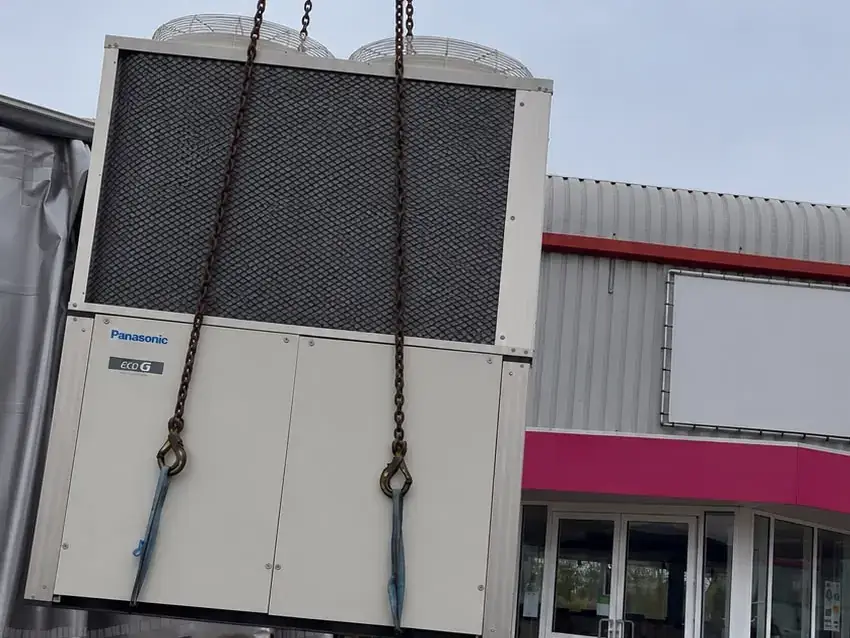Panasonic ECO G buitenunit wordt met een kraan naar het dak van een bedrijfspand in Zoeterwoude gehesen